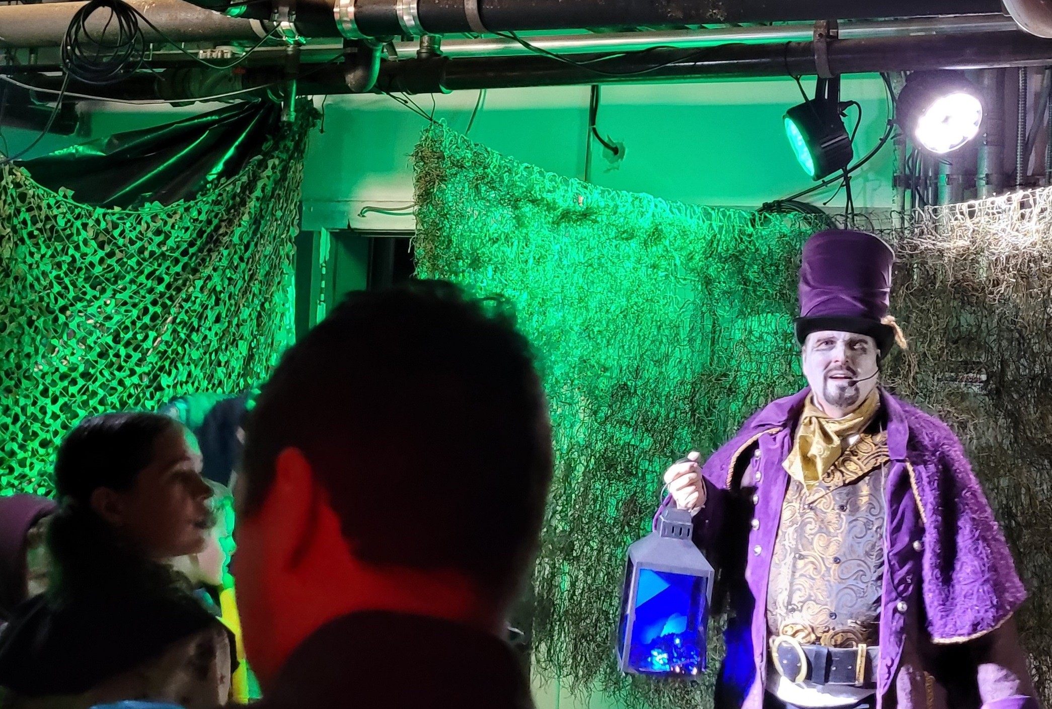 ouring Halloween haunt scene with costumed actor guiding guests