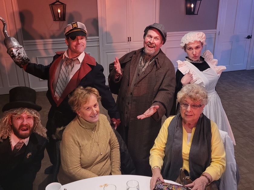Senior residents enjoying a murder mystery performance with Riddlesbrood Touring Theater actor dressed as a detective in NJ retirement community